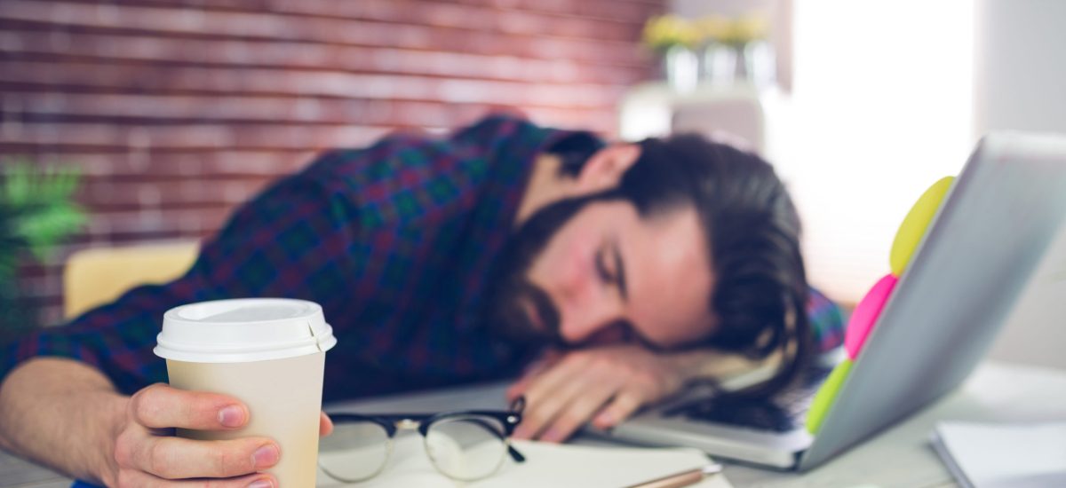 Tired,Creative,Editor,Holding,Disposable,Cup,While,Sleeping,On,Office