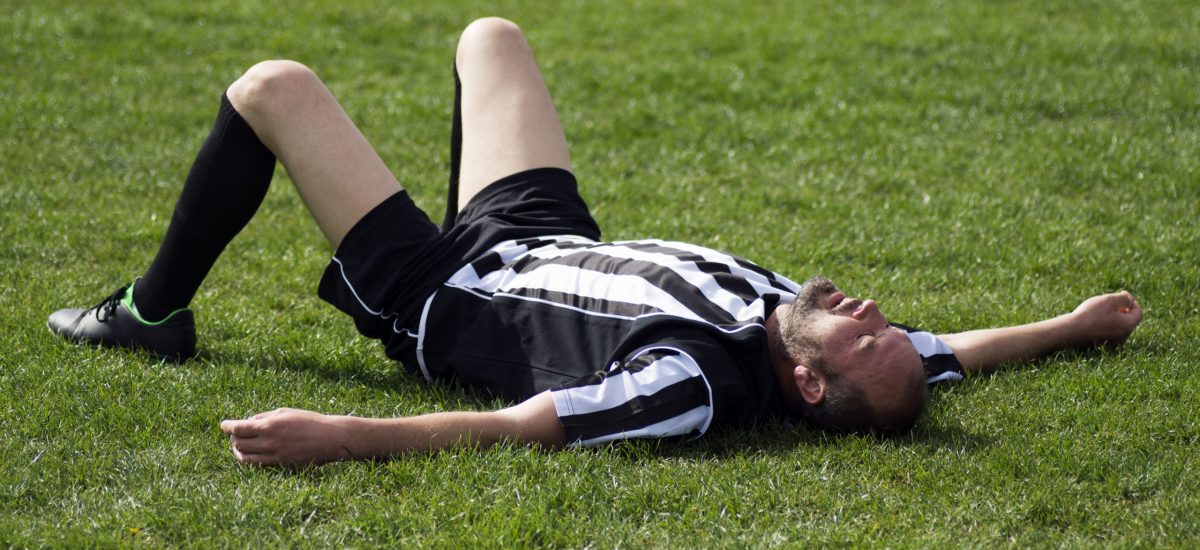 The,Tired,Soccer,Player,Is,Lying,Down,On,The,Grass